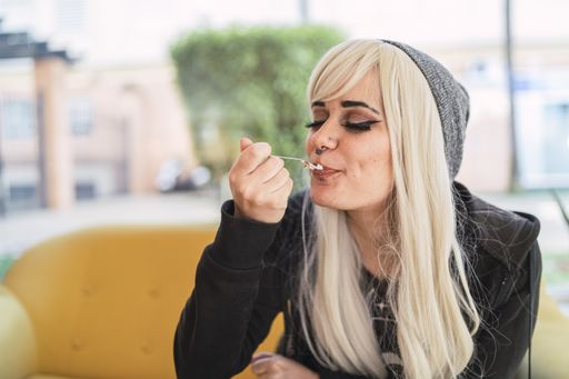 A cute young Spanish woman with blond hair and piercings enjoying her dessert