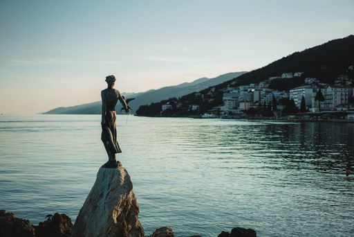A majestic view of The statue of Opatija, symbol of the Kvarner Golf in Croatia overlooking a lake