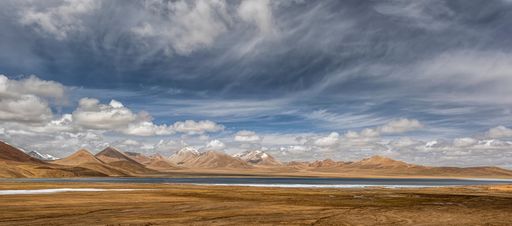 The stunning landscape in the Ali region of Tibet, with majestic mountains and a tranquil blue lake