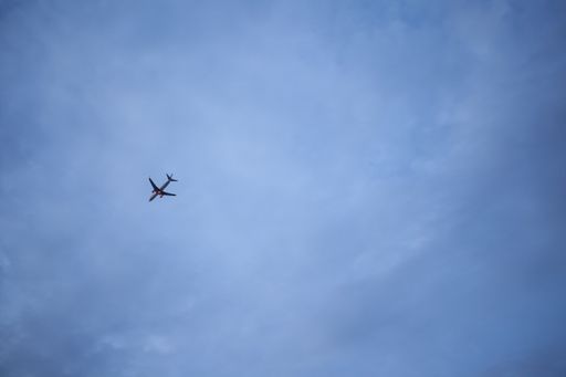 A low angle shot of a plane flying under a blue cloudy sky in the evening - great for wallpapers