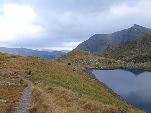 This stock photo features a scenic view of a peaceful lake located along the Pic de la Serrera trail in Andorra