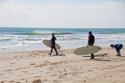 A group of surfers going out to sea to enjoy the waves in the Spanish Mediterranean