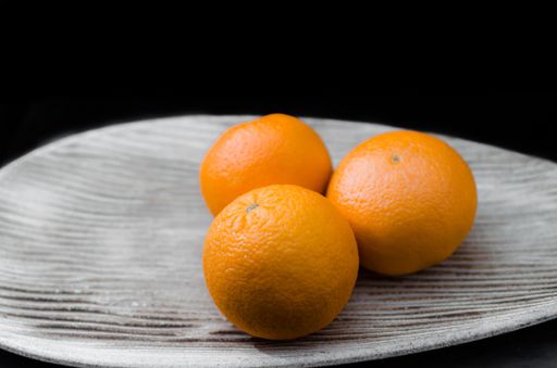 A closeup shot of three fresh grapefruits on a plate