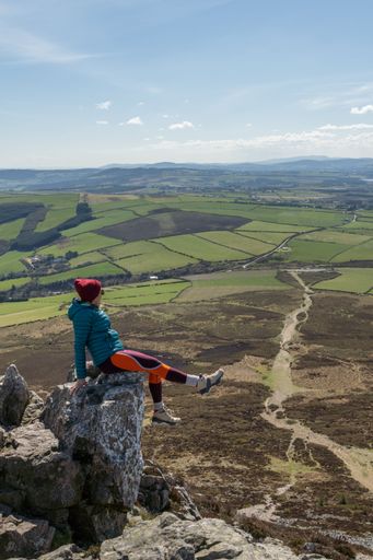 A high angle shot of a hiker enjoying the view from the Sugar Loaf Mountain Viewpoint in Ireland