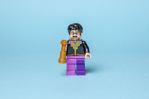 A miniature John Lennon Lego action figure on a bright blue backdrop