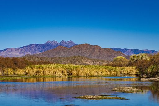 the rocky mountains near the water under the clear sky in Phon D Sutton Recreation area Mesa USA