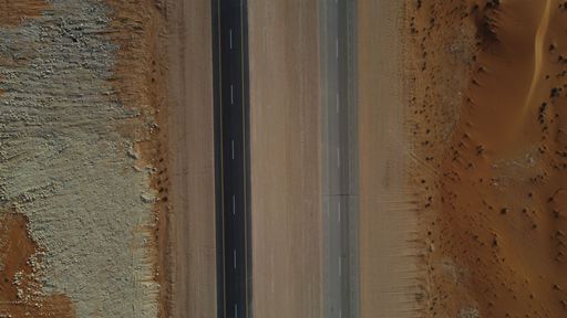 A closeup of the road in the middle of the desert in Saudi Arabia on a sunny day