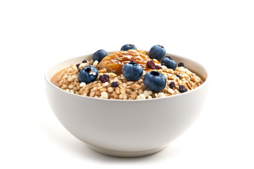 A white ceramic bowl containing a healthy and nutritious breakfast of oatmeal and fresh mixed berries