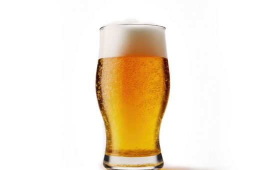 An image of a person pouring a cold, golden-hued beer into a tall glass against a plain white background