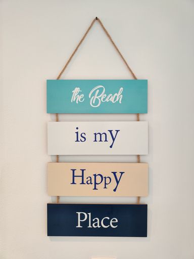 A closeup shot of a quote hanging on a white wall.