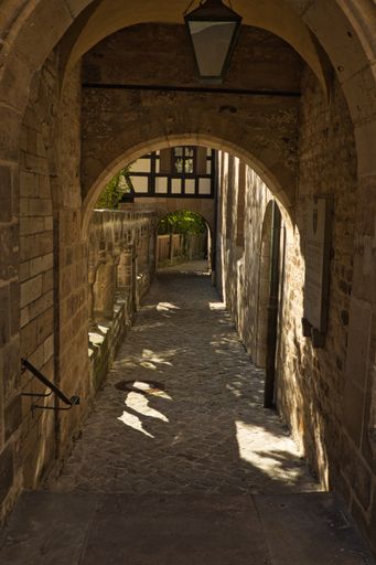 A vertical shot of a route in an old building with arches