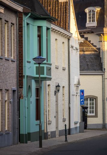 A scenic street in a bustling city, featuring quaint buildings with colorful doors, windows, and balconies
