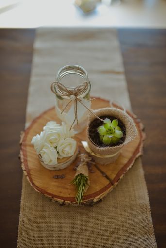 A selective focus shot of eco-style wedding decorations on a small wooden stump