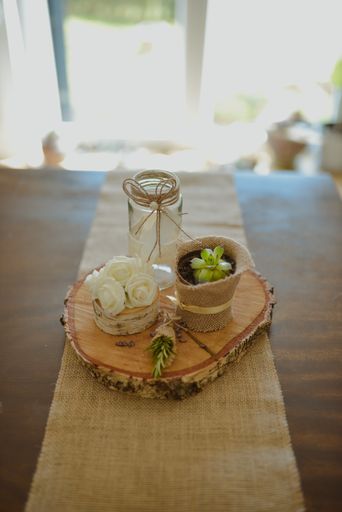 A selective focus shot of eco-style wedding decorations on a small wooden stump