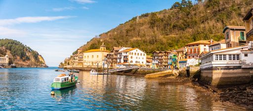 A panoramic shot of a beautiful coastal town Pasajes in Spain surrounded by greenery-covered hills