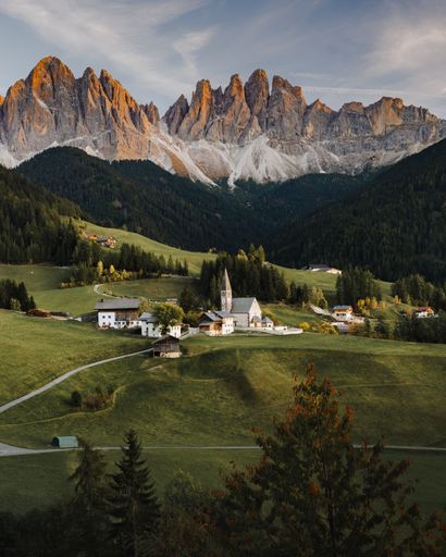 A beautiful sunset over a church in the Dolomites Mountains, Italy.