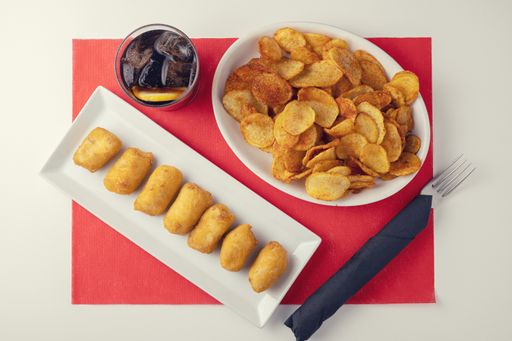 A top view of fresh crispy potato chips and tasty nuggets on a table