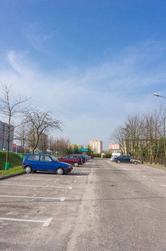 POZNAN, Parked cars on a parking lot with apartment block in the background on the Osiedle Polan area