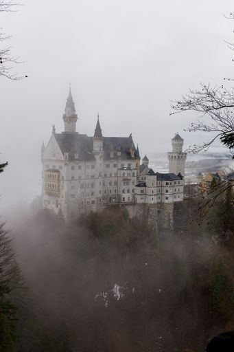 A vertical photograph of the historic 19th century castle Neuschwanstein situated in the German countryside