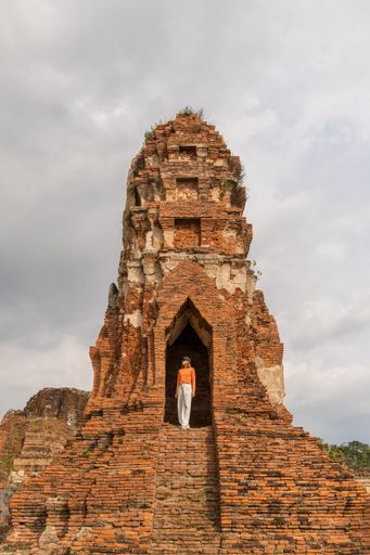 An Asian tourist admiring the Wat Ratchaburana temple in Ayutthaya, Thailand