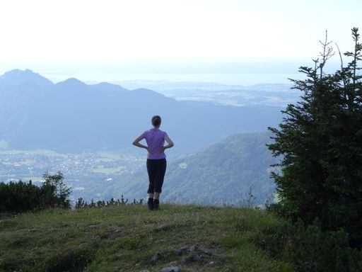female hiker looking down to the valley from top of Kienberg, Chiemgau alps near Ruhpolding, Germany
