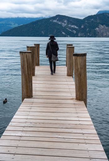 A person walking on a wooden dock and enjoying a beautiful seascape view