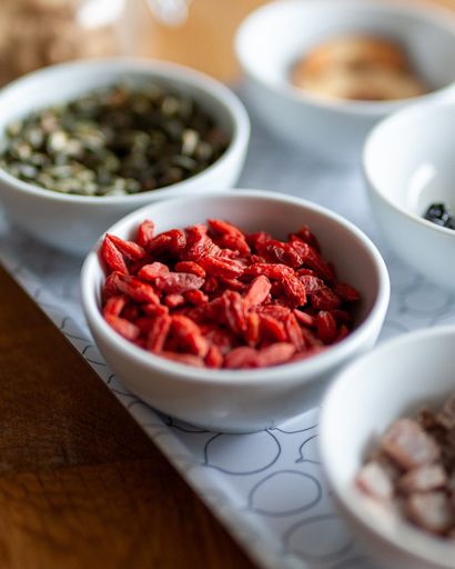 A vertical shot of goji berries in a white bowl on the table