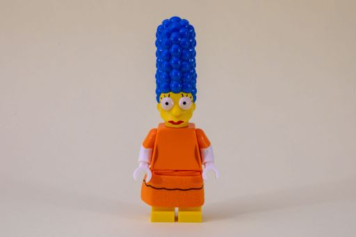 A cheerful Lego figure in orange clothing and blue hair is wearing a vibrant blue wig, bringing a fun and playful atmosphere to the scene