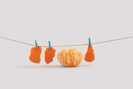 A creative summer concept with peeled tangerine isolated on a white background