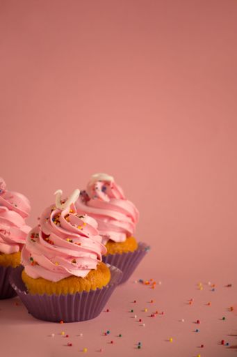 A variety of colorful cupcakes with various types of frosting