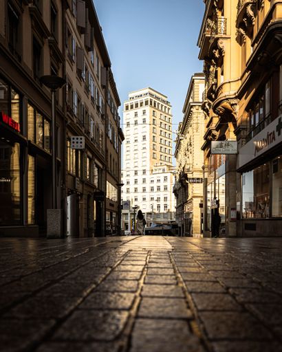 A wide view of a bustling city street, featuring a tall buildings in Lausanne