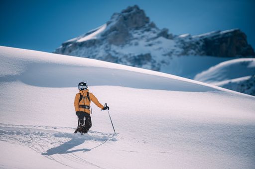 A young man skiing down a snowy mountain slope