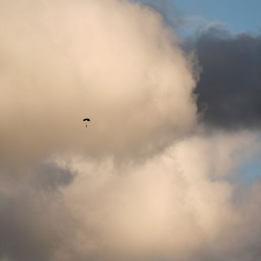 A vertical shot of a paraglider amongst dramatic clouds in Voss, Norway