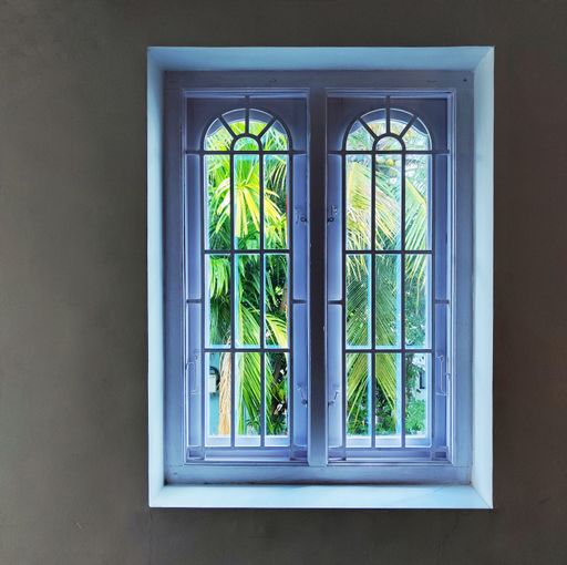 A still image of a room interior, featuring a window with a reflection in the glass