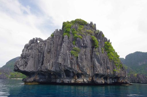 A low angle shot of mossy cliffs in the sea