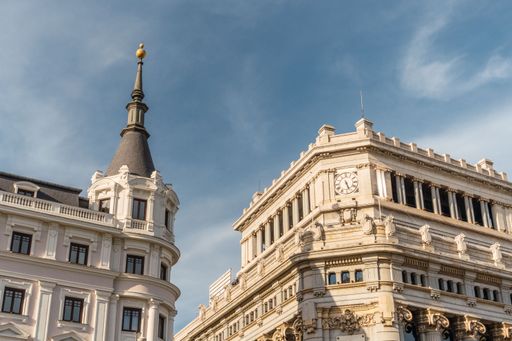 View of the upper part of european building with a clock in Madrid, Spain