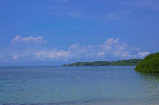 A scenic view of a calm sea under a clear blue sky background