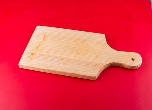 This image features a wooden board isolated on a vivid red background