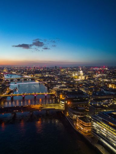 An aerial view of the London skyline illuminated during blue hour, United Kingdom.