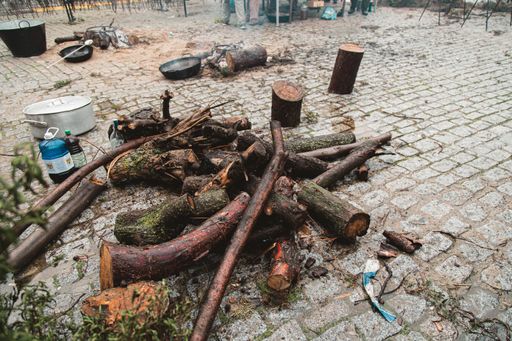 A high angle view of lumber for a bonfire surrounded by pots and pans in a park