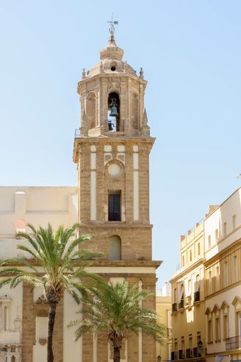 A vertical shot of the Santiago Apostol church under the sunlight and a blue sky in Cadiz, Spain
