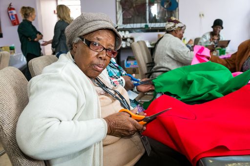 A senior African American female doing arts and crafts at an event