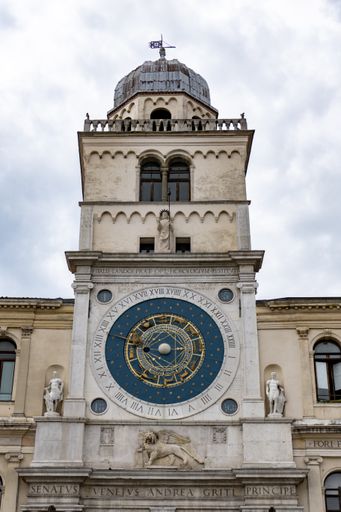 A vertical shot of a clock tower with sculptures under a cloudy sky in Piazza dei Signori Padua Italy