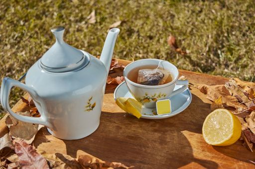 A high angle shot of a cup of delicious hot tea with lemon slices outdoor