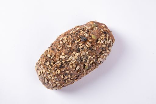 An overhead shot of a freshly baked bread topped with grains and seeds