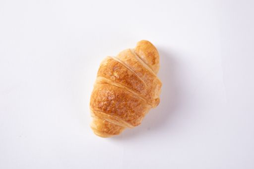 An overhead shot of a freshly baked croissant isolated on white background