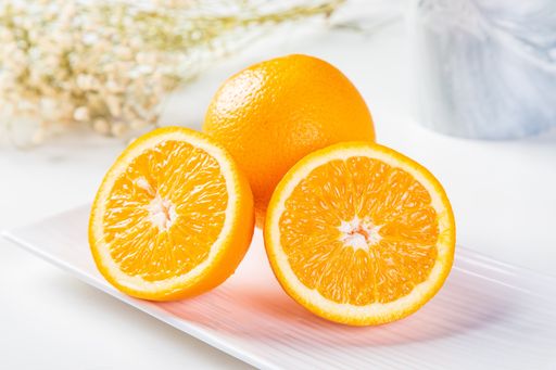 A closeup of cut oranges on a plate on the table with a blurry background