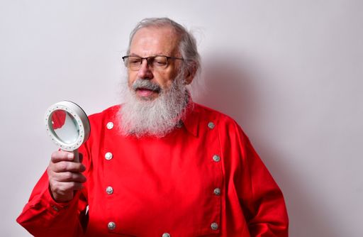 Old American male holding a magnifying glass