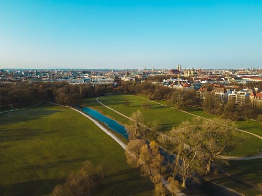 Aerial view of the English Garden in Munich. In the background you can see the Bavarian capital city with the cathedral Frauenkirche at Marienplatz.