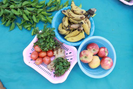 Ripe fruits and vegetables and clementine branches on blue background